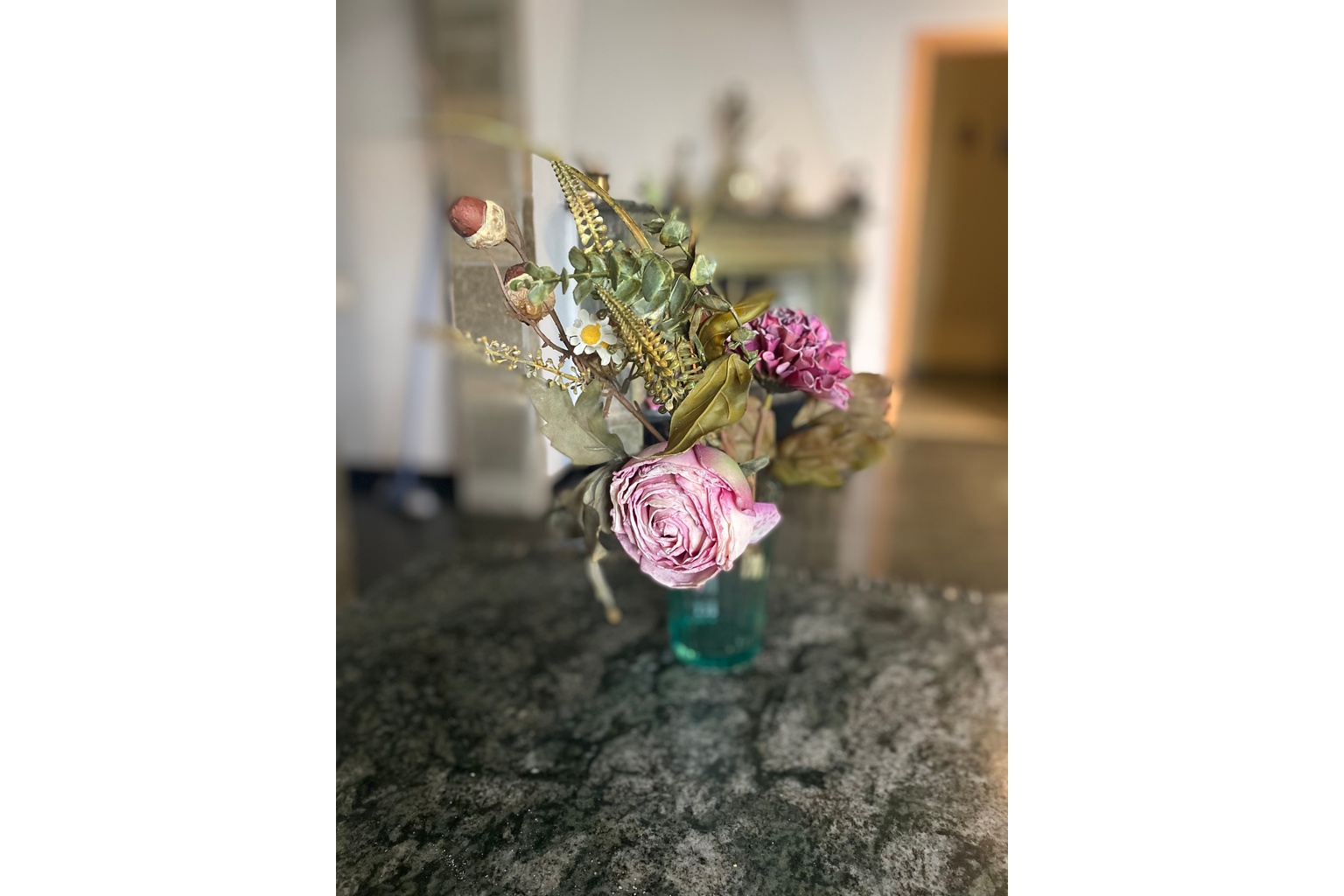 sztuczne kwiaty na stoliku w wazonie